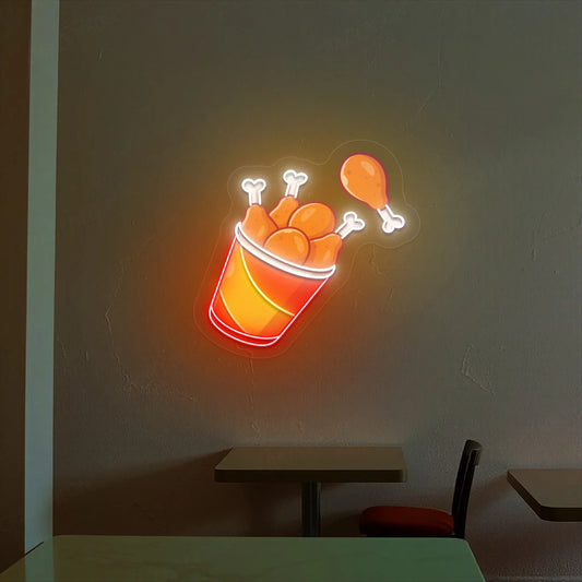 Neon sign of a bucket of fries and chicken drumsticks on a dark wall.